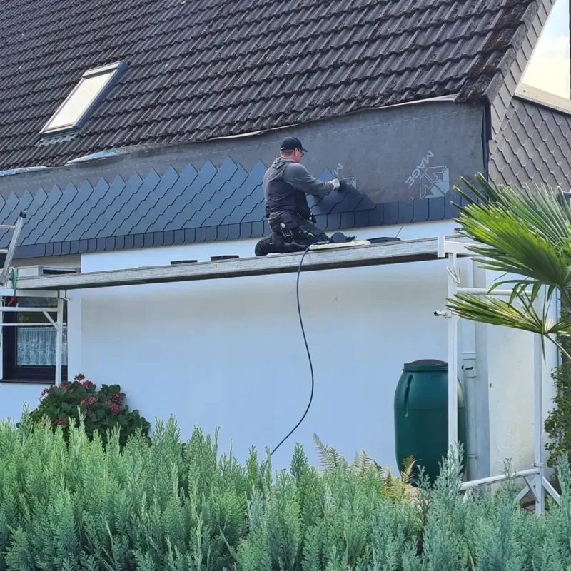 Arbeiter an einer mit Schiefer verkleideten Fläche