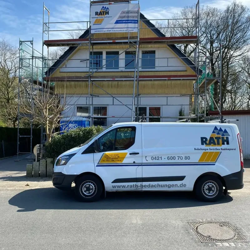 Firmenfahrzeug vor einem eingerüsteten Wohnhaus